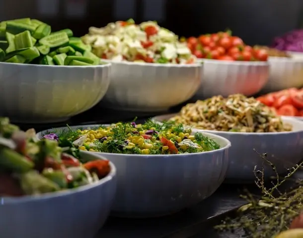 Bowls de porcelana branca cheios de salada alinhados lado a lado o que e PAT programa de alimentacao ao trabalhador